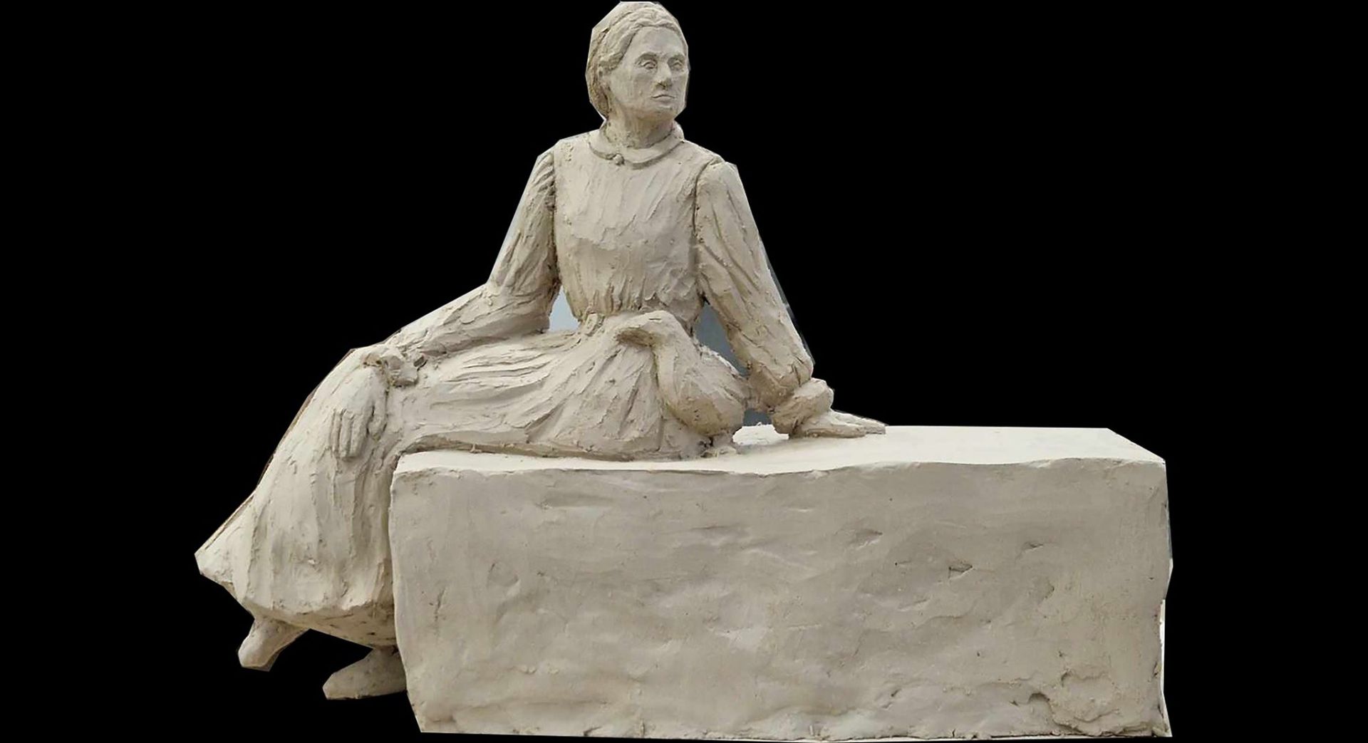Miniatyrmodell i lera av styatyn Gynnarinna av Iida Nurminen som föreställer Charlotta Lönnqvist i sidenklänning sittande på en granitsten med en anka i sin famn